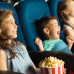 Group of happy kids enjoying a movie at the cinema