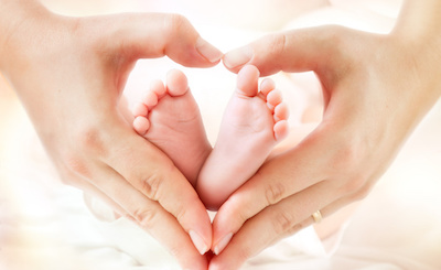baby feet in mother hands – hearth shape