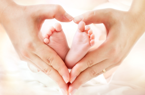 baby feet in mother hands – hearth shape