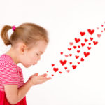 Little kid is sending heart shaped kisses