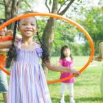 Cute diverse kids playing with hula hoops
