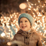 portrait of happy girl in winter evenings on background of Christmas lights