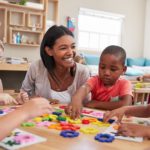 Teacher And Pupils Using Flower Shapes In Montessori School