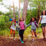 Boys and girls running in the forest together
