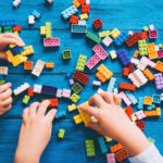 Children play and build with colorful toy bricks, plastic blocks.
