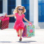 Little girl with shopping bags goes to the store
