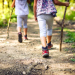 Children hiking in mountains or forest with sport hiking shoes.
