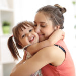 love and family people concept – happy mother and child daughter hugging at home