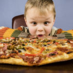 boy eating a large pizza