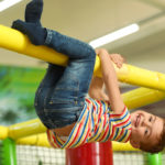 Cute little child playing at indoor amusement park