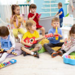 Children learning musical instruments on lesson in kindergarten or preschool