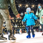 Skating rink. Family wearing the medical face masks on the ice r