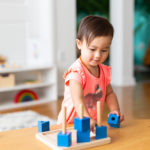 Toddler Girl Playing and Exploring with Montessori Lessons