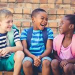 Happy school kids sitting together on staircase
