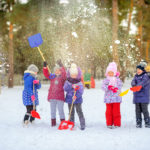 children play in the winter park, throw snow and have fun