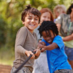 Learning teamwork through play. A group of kids in a tug-of-war game.