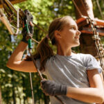 Little girl leisures in rope park, playground