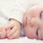 close-up portrait of a beautiful sleeping baby on white