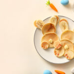 Funny Easter bunny pancakes with painted eggs on white background