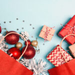 Red shopping bags with christmas decoration and gifts  on a blue