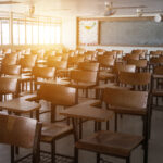 Empty classroom with vintage tone wooden chairs. Back to school concept.