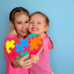 Heart in Viva Magenta color for children with autism in the hands of girls