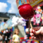 sweet candy apple on county fair or festival. red candy apple covered in caramel, at holiday vacation event. German paradiesapfel