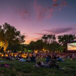 Movie-goers gather in a lively park, immersed in the entertainment under the stars.