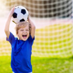 Kids play football. Child at soccer field.