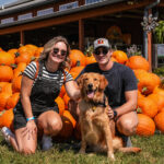 dog and young adults pumpkins