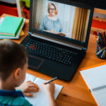 Distance learning online education. A schoolboy boy studies at home and does school homework. A home distance learning